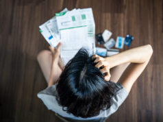 Pedir Crédito consolidado: Quais os requisitos e como solicitar? mulher a olhar para as contas a tentar entender como solicitar crédito consolidado.