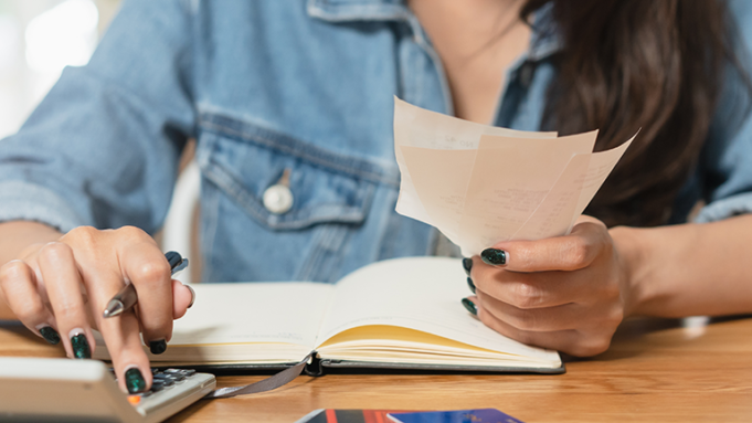 senhora sentada a mesa a fazer calculos das contas mensais senhora sentada a mesa a fazer calculos das contas mensais